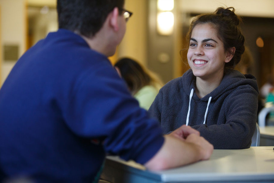 Two students smiling while talking.