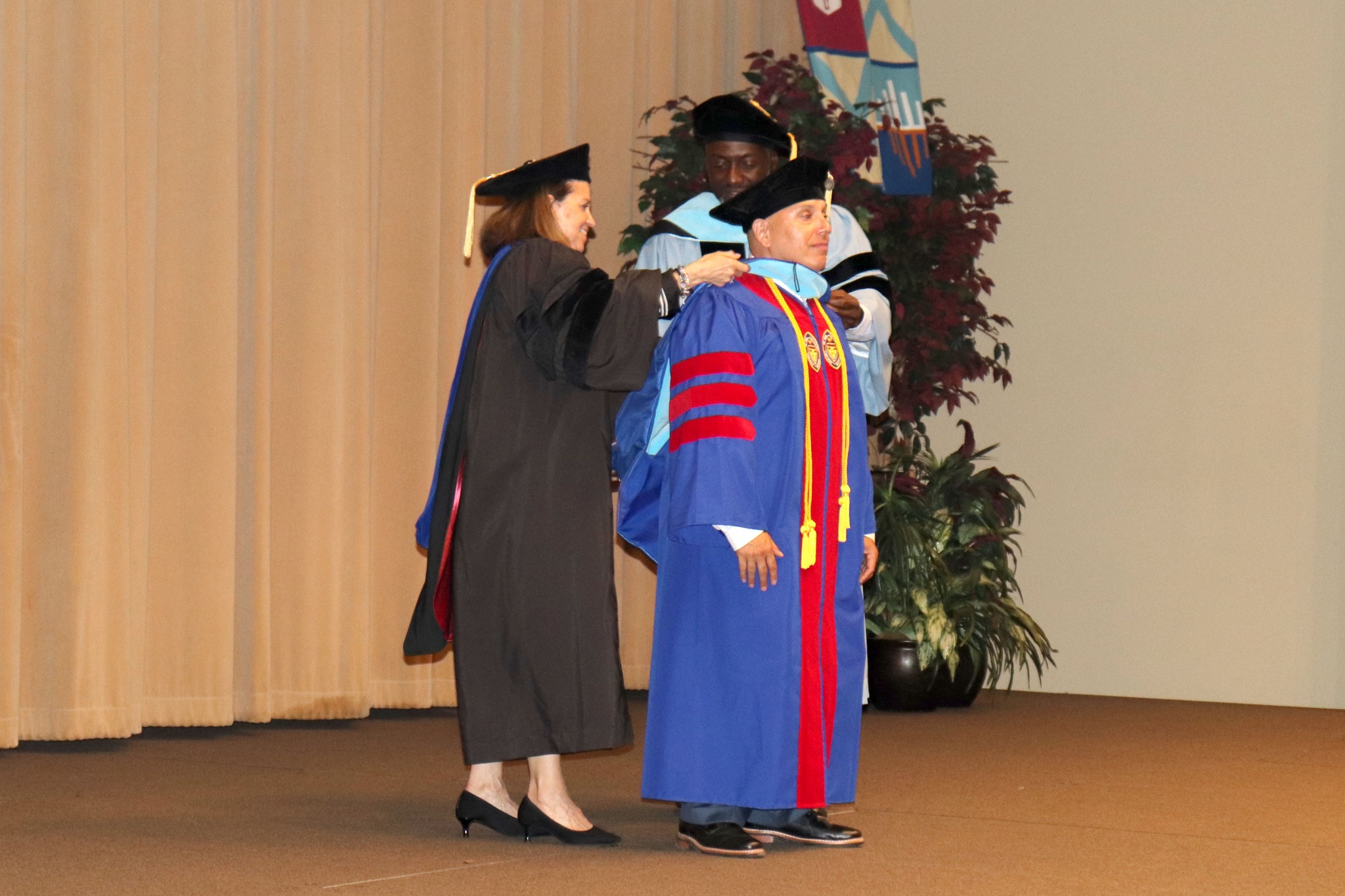 Two professors hooding graduate