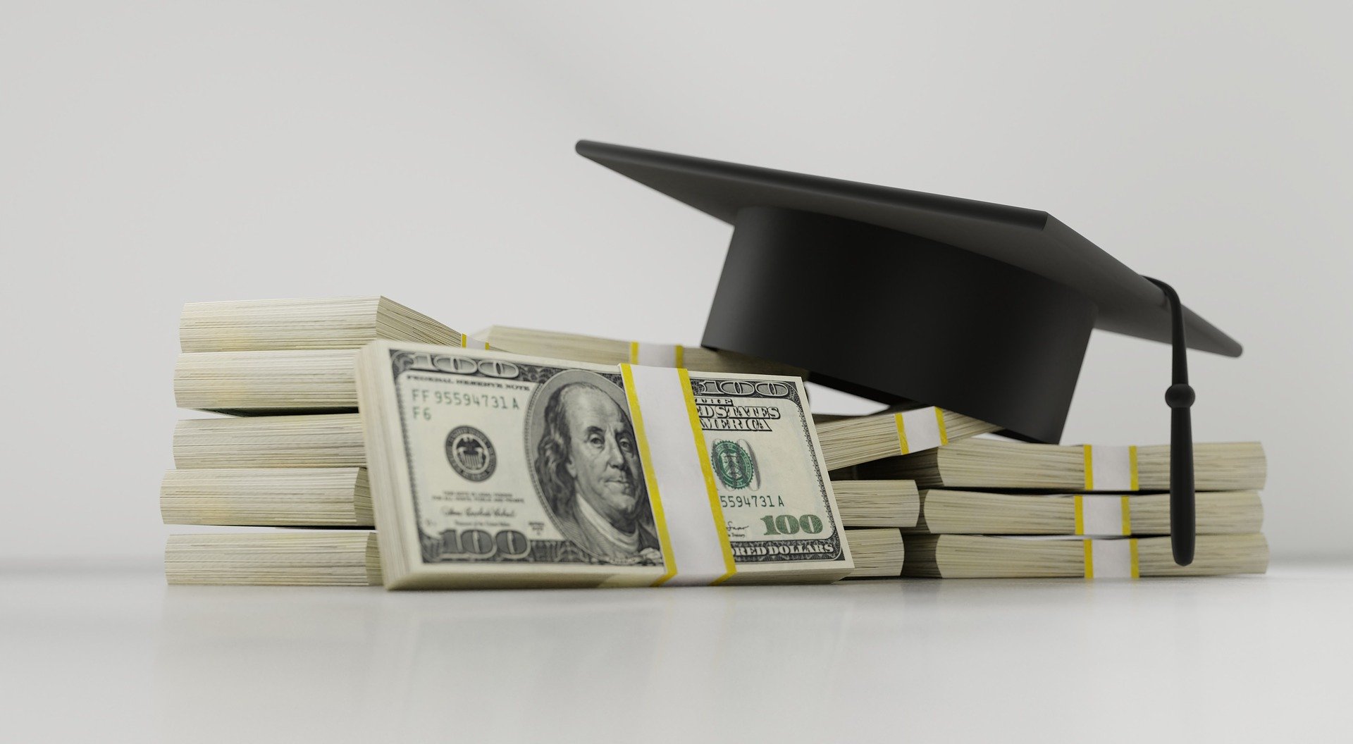 Graduation cap and stacks of money